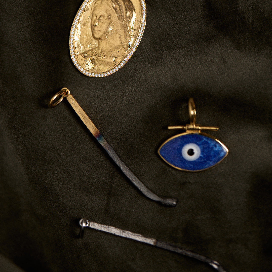 Collection of vintage-style pendants on a dark fabric background