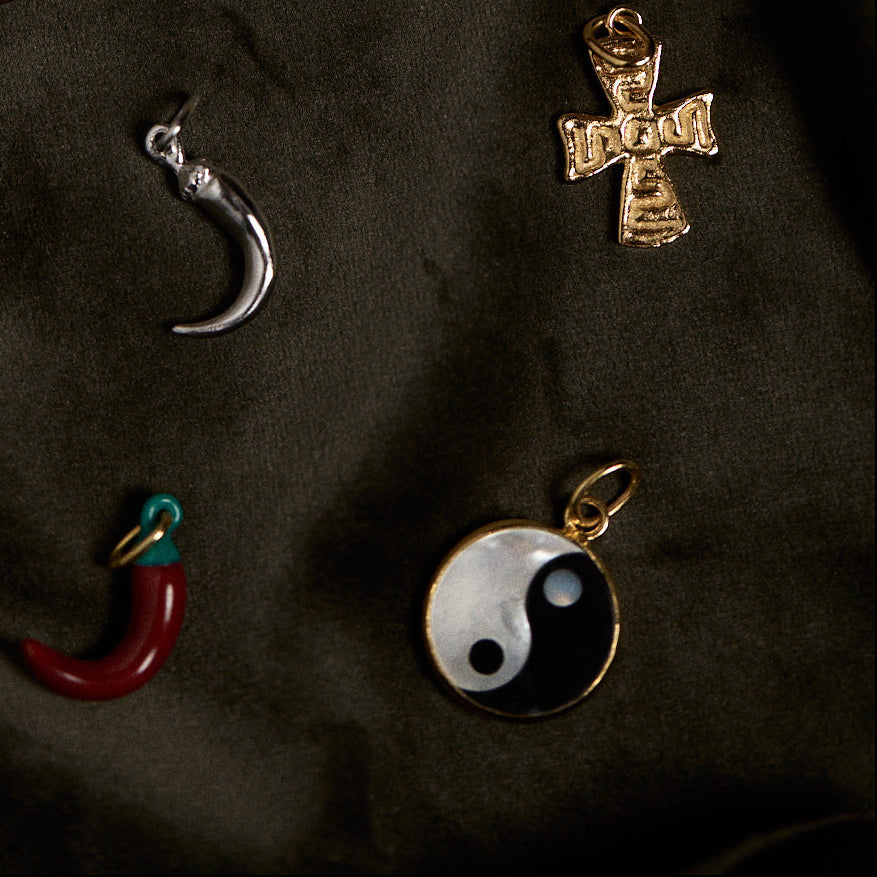 Collection of various pendants on a dark fabric background